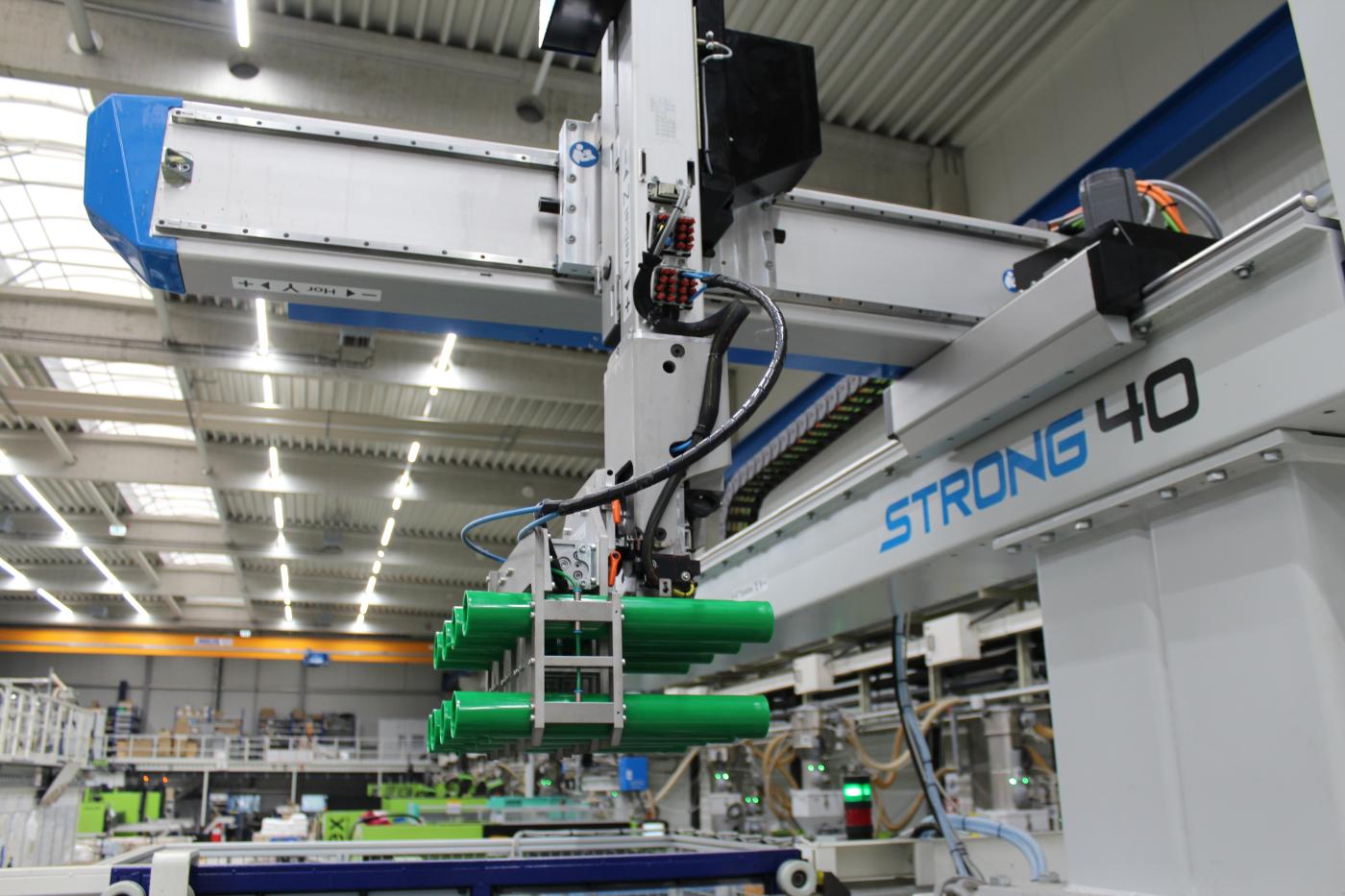 Gripper arm transports QUADRO tubes onto conveyor belts