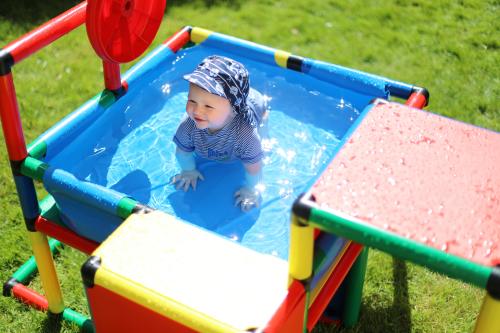 Un enfant dans une structure d’escalade avec piscine