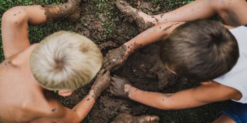 Deux petits garçons creusent dans la boue