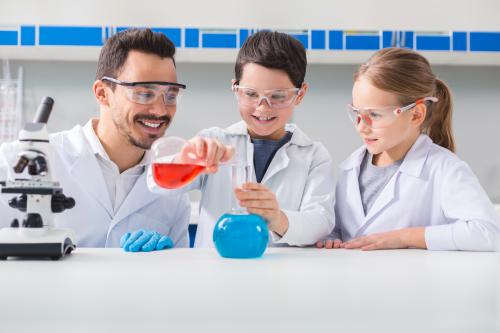 Man and children conducting a science experiment