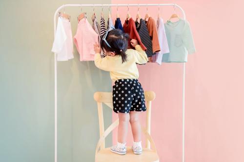 Une petite fille choisit des vêtements