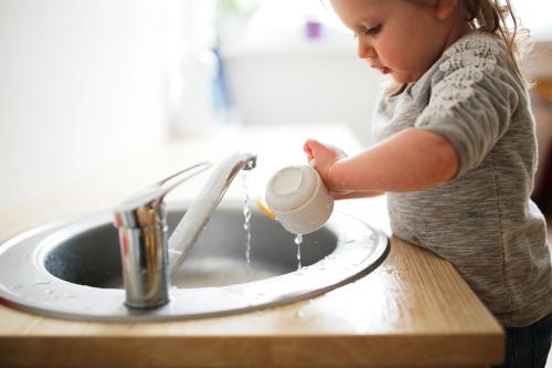 Une petite fille lave une tasse