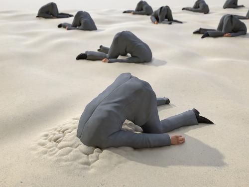 Men in a suit with their head in the sand