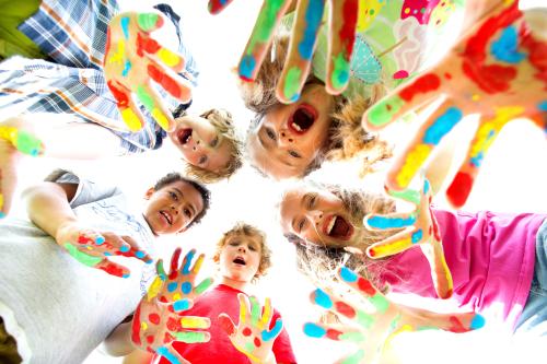 Des enfants avec les mains recouvertes de peinture multicolore