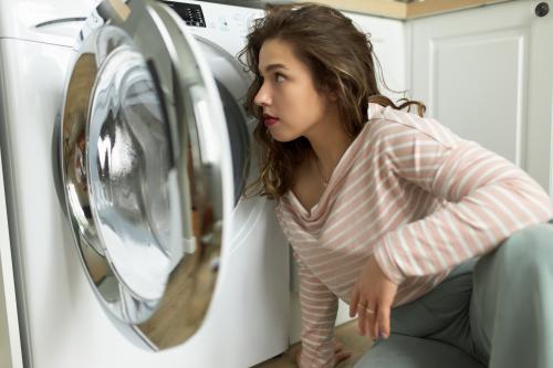 Frau schaut in Waschmaschine