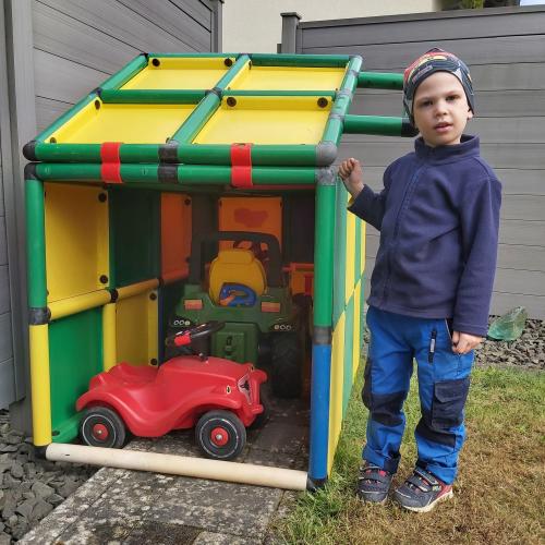 Petit garçon devant un garage QUADRO